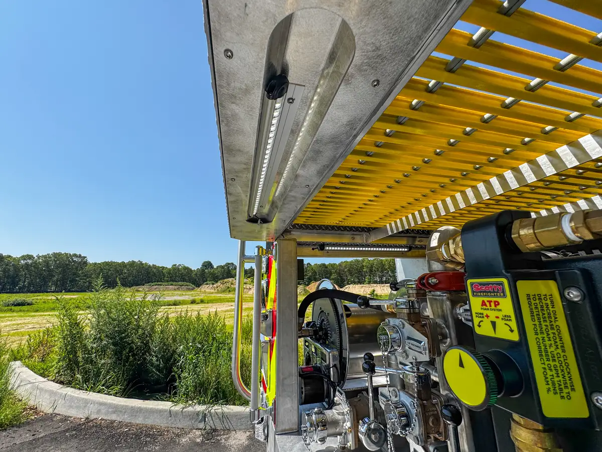 Underside compartment close-up along yellow grating and side hardware.